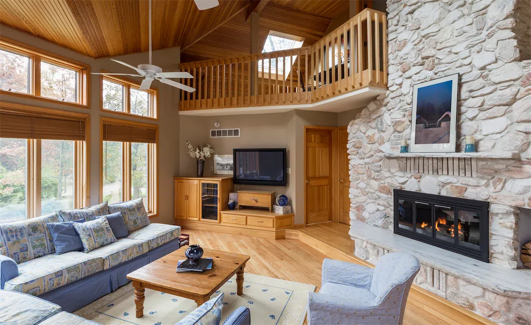 A beautiful stone fireplace in an Alaskan living room, a feature that adds value to a rental property.